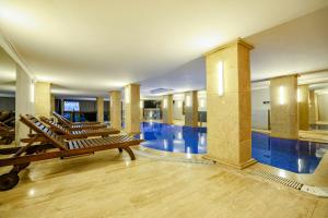 a pool with a row of lounge chairs in a building at Boğaz Manzaralı Havuzlu Lüks Villa in Istanbul