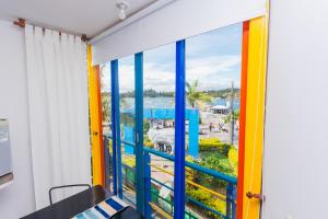 a room with a balcony with colorful windows at Hotel Guatatur in Guatapé