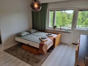 a bedroom with a bed in a room with a window at City Apartment Aarneenkallio & free parking in Kuopio