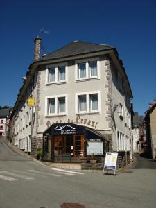 ein großes weißes Gebäude mit einem Schild davor in der Unterkunft Le Levant in Besse-et-Saint-Anastaise