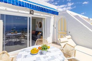 a patio with a table and chairs on a balcony at Panoramic View Tamara Apt By Dream Homes Tenerife in Acantilado de los Gigantes