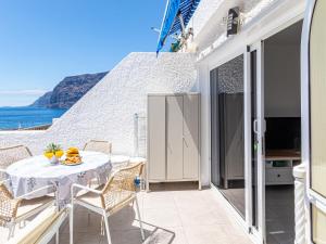 a balcony with a table and chairs and the ocean at Panoramic View Tamara Apt By Dream Homes Tenerife in Acantilado de los Gigantes