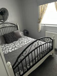 una camera da letto con un letto con un piumone bianco e nero di Cairnryan Heights home from home a Cairnryan Altre 12 foto