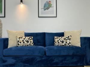a blue couch with pillows in a living room at Central City Two-Bedroom in Swindon