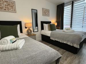 two beds sitting next to each other in a bedroom at Central City Two-Bedroom in Swindon