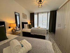 a bedroom with two beds and a window at Central City Two-Bedroom in Swindon +22 photos
