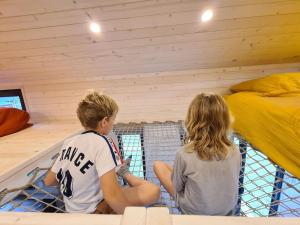 two people sitting on a net in a room at l'escale de Normandie in Saint-Martin-au-Bosc