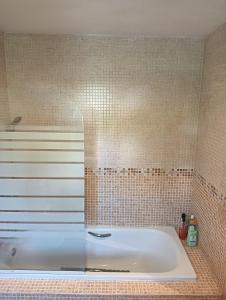 a bath tub in a tiled bathroom at A Parrula, Mar, río y montaña in Sotomayor
