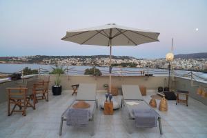 a patio with an umbrella and tables and chairs at Porta Harenae Residencia in Chania