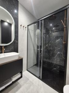 シュチェチンにあるHanza Tower 13 floorのガラスのシャワーと洗面台を備えたバスルーム