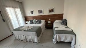 una camera d'albergo con due letti e una finestra di Resort Tree Bies - Subauma a Subaúma