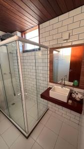 un bagno con lavandino e doccia in vetro di Resort Tree Bies - Subauma a Subaúma