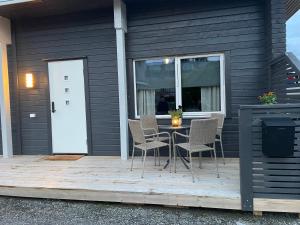 a patio with a table and chairs on a house at Leilighet midt i sentrum av vakre Hattfjelldal in Hattfjelldal