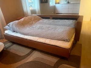 a unmade bed in a room with a table at Leilighet midt i sentrum av vakre Hattfjelldal in Hattfjelldal +5 photos
