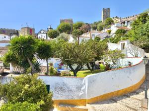 a view of a town with trees and buildings at Casa do Candeeiro in Óbidos
