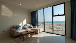 a living room with a couch and a large window at دار الرياض للشقق المخدومة بالخبر 2 in Al Khobar