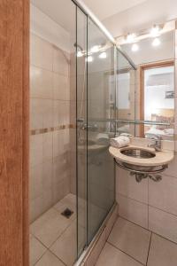 a bathroom with a glass shower and a sink at Apart Hotel Rio Grande in Rosario