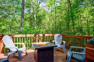 Dos sillas y una mesa en una terraza con parrilla. en Blue Ridge Mountain Cabin Rental with Fire Pit!, en Murphy