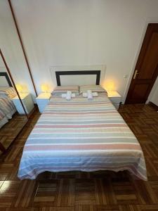 ein Schlafzimmer mit einem großen Bett mit zwei Lampen in der Unterkunft Apartamento Santander, Playa Sardinero in Santander