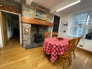 a dining room with a table and a fireplace at Tyn Y Fron 6 bedroom house in Betws-y-Coed Snowdonia in Betws-y-coed