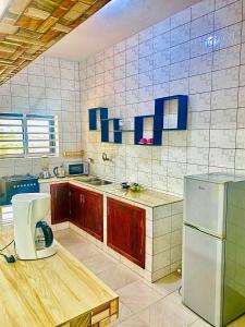 a kitchen with wooden cabinets and a white refrigerator at Appartement climatisé et cozy-C1 in Abomey-Calavi +11 photos