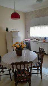 a kitchen with a table with a vase of flowers on it at chalé vista para montanha in Penedo +14 photos