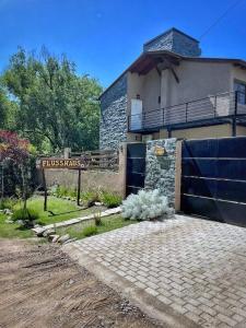 ein Haus mit einem blauen Zaun und einem Schild in der Unterkunft Flusshaus8 in Villa General Belgrano
