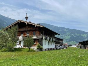 drewniany dom na polu z górami w tle w obiekcie Blick zum Mayrhofen w mieście Ramsau im Zillertal
