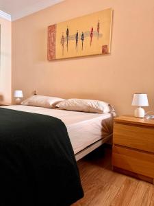 Un dormitorio con una cama y un cuadro en la pared. en Luna C, en Puerto de la Cruz