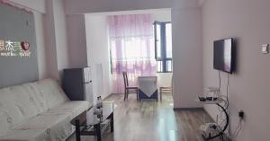 方远滨江国际 في هاربين: غرفة معيشة مع أريكة بيضاء وطاولة