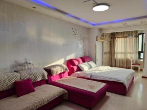 方远滨江国际 في هاربين: غرفة معيشة بها سريرين وأريكة