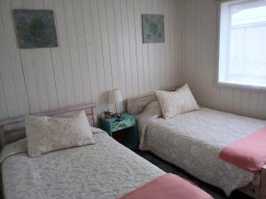 a bedroom with two beds and a table with a lamp at Vintage Hostal in Puerto Montt