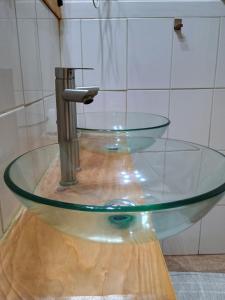 a glass sink with a faucet in a bathroom at Vintage Hostal in Puerto Montt