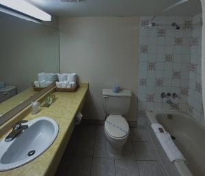 ein Badezimmer mit Waschbecken, Toilette und Badewanne in der Unterkunft The Fort Hotel in Fort Nelson