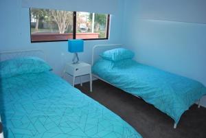 a bedroom with two beds and a window at Cosy Beach Pad - Two Bedrooms in Marcoola