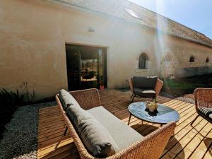 un patio con un divano e un tavolo di Gîte de charme à la ferme avec jardin clos et activités familiales - FR-1-591-582 a Thenay
