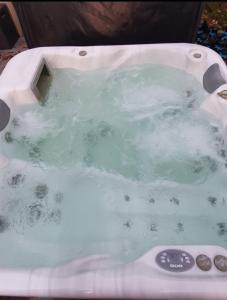 a bath tub with water in it with aperature at Les Agapanthes in Le Tour-du-Parc