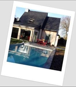 a house with a swimming pool in front of it at Les Agapanthes in Le Tour-du-Parc