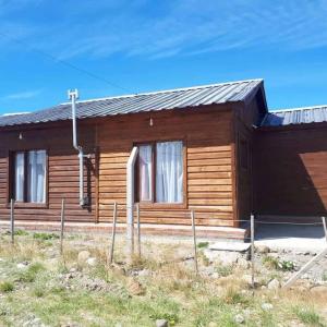 a wooden house with windows on the side of it at Lugar tranquilo para descansar in El Calafate