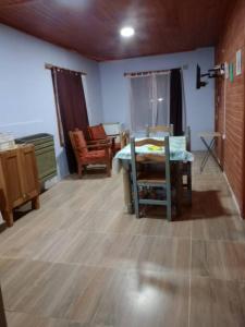 a living room with a table and chairs in it at Lugar tranquilo para descansar in El Calafate