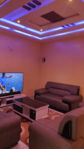 a living room with a couch and a flat screen tv at Liberty Guesthouse in Abomey-Calavi