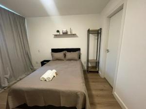 a bedroom with a bed with two towels on it at Loft Barra da Tijuca - Ilha Pura - Rock in Rio, Riocentro in Rio de Janeiro +21 photos
