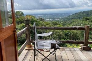 una silla sentada en la cubierta de una casa en 壮观景色的宁静木屋, en Santa Ana