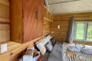 Un dormitorio con una cama en una cabaña de troncos en 壮观景色的宁静木屋, en Santa Ana