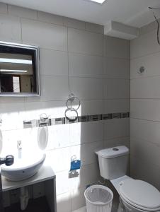 a bathroom with a toilet and a sink and a mirror at FAKALI Homestay in Quito +38 photos