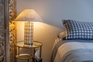 a lamp on a side table next to a bed at Once upon a Cosy Nook in Dunedin
