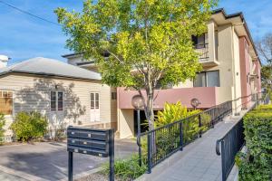 una casa con una puerta y un árbol delante de ella en Bright 2-Bed with Private Balcony & Serene View, en Brisbane