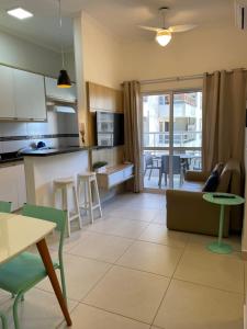 a kitchen and living room with a couch and a table at Ubatuba - Recanto Praia das Toninhas in Ubatuba