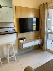 a kitchen with a large flat screen tv on a wall at Ubatuba - Recanto Praia das Toninhas in Ubatuba