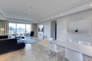 a living room with a large white table and chairs at 401 Apartment in Cape Town